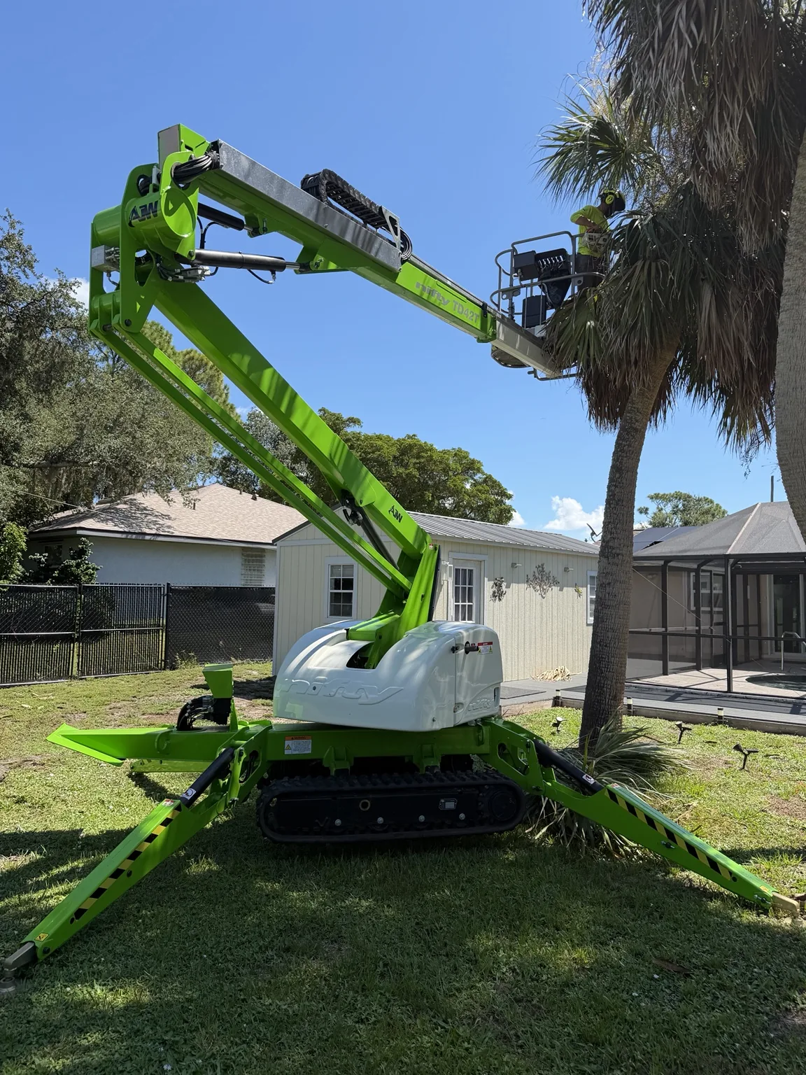 AJW Tree LLC tracked lift performing professional tree work in Southwest Florida
